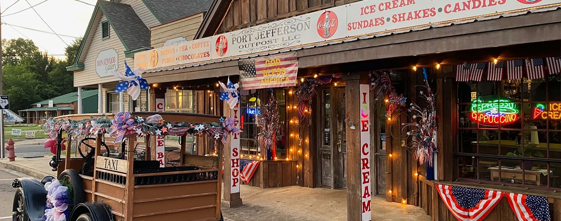 A quaint ice cream shop adorned with festive decorations and a vintage taxi outside.